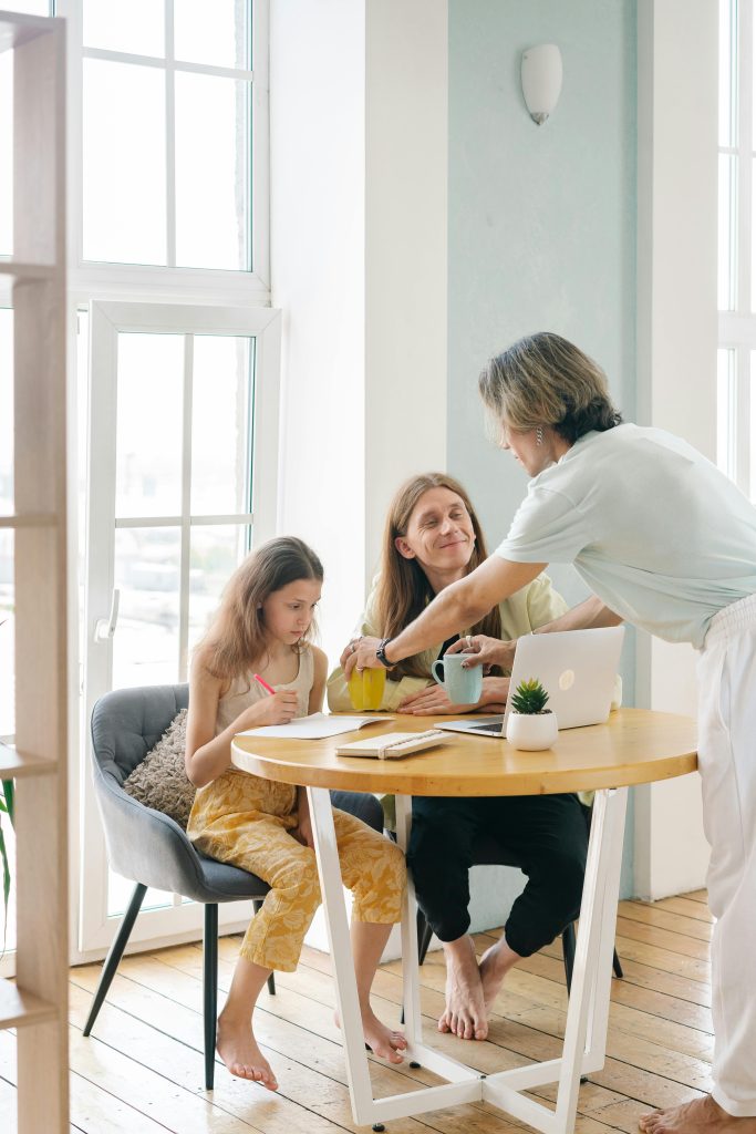 A family gathers around a table for drinks, showcasing togetherness and joy.